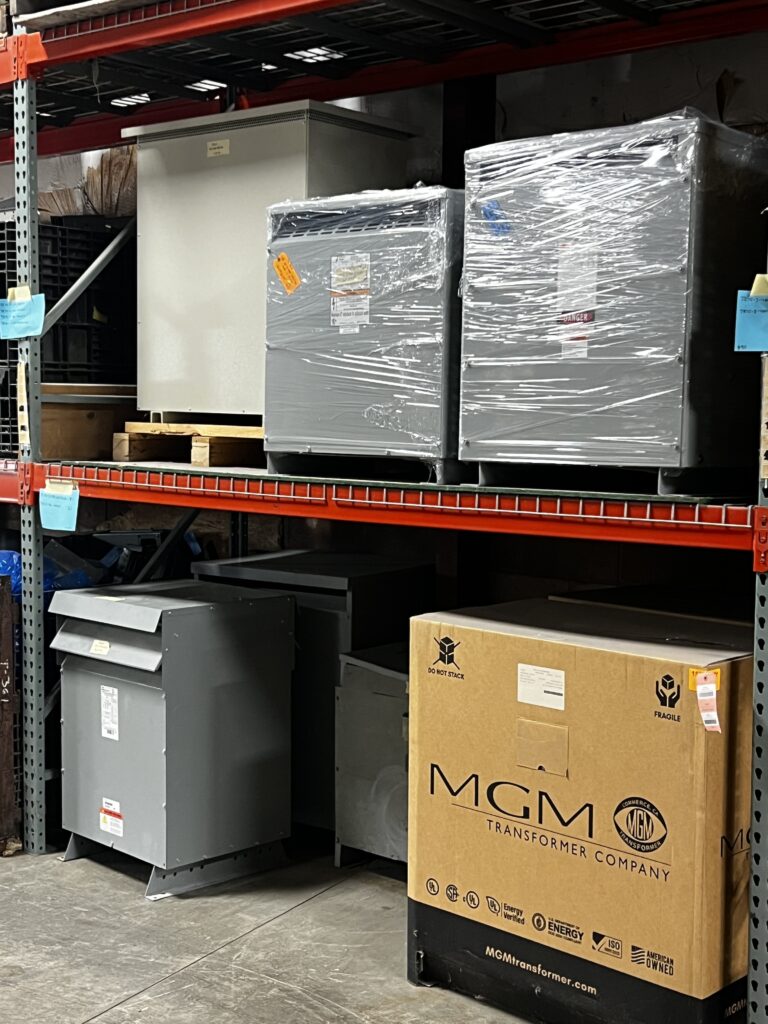 metal shelving filled with circuit breakers, bus plugs, and disconnects